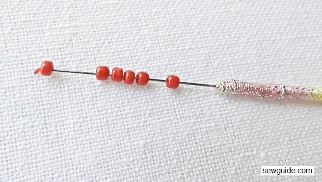 insert the needle on the needle through the loop