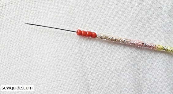 beads are taken on the aari work needle