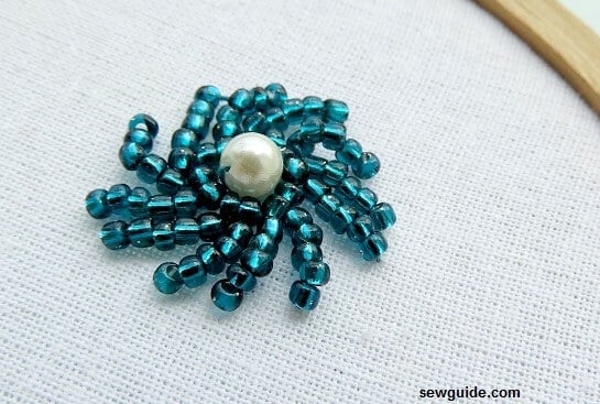 Beads decorated in a swirl around a pearl