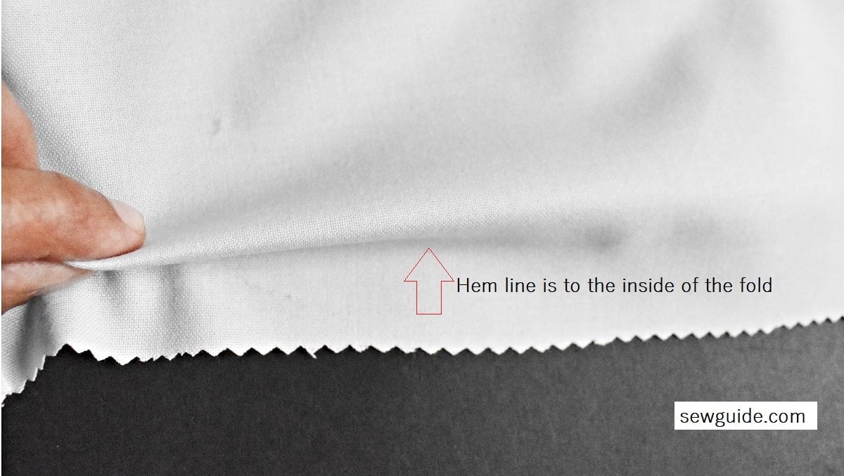fold the fabric so that the marked hem line appears in the middle of the fold