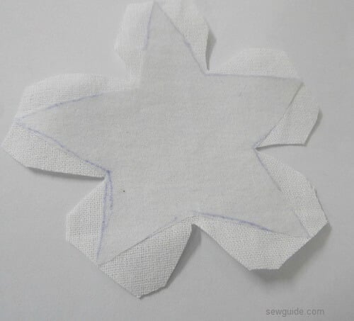cut out star shape from fabric to make handmade christmas tree ornaments