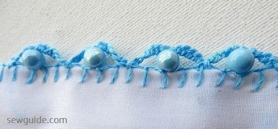 Add beads in between the scalloped stitches