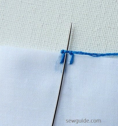 The needle is inserted through the buttonhole stitch and then thread is twisted through the needle several times to make the knot