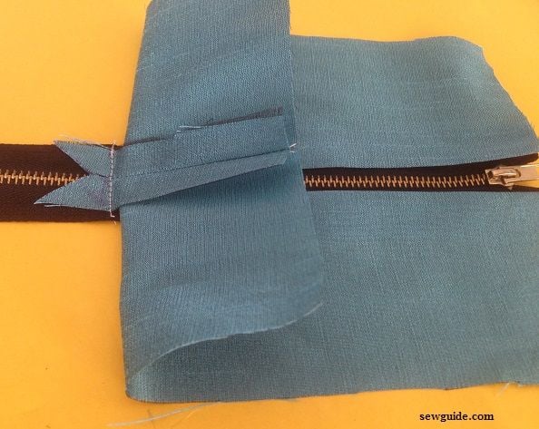 sew the seam allowance to the zipper on the back