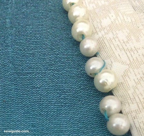 small round beads stitched on the hem with hemming stitches
