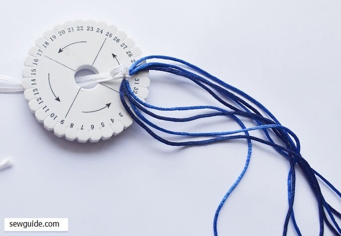 bring up the tied cord through the hole in the kumihimo braid tool