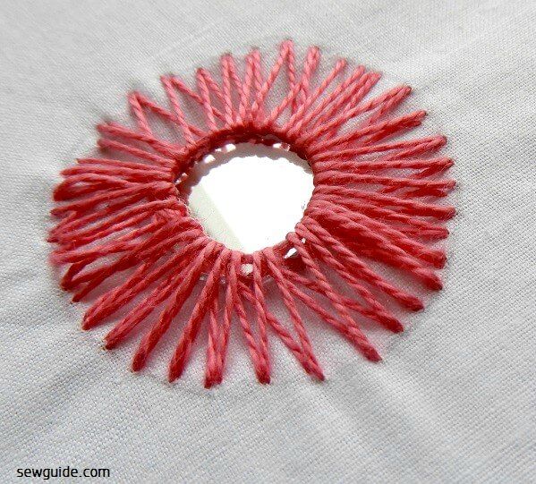 Pointed straight stitches are made around the mirror