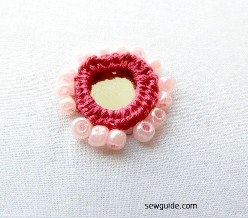 Attach beads around the mirror