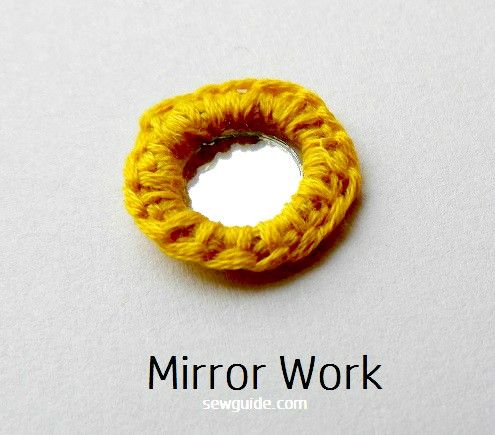 mirror is decorated with embroidery work around its edges