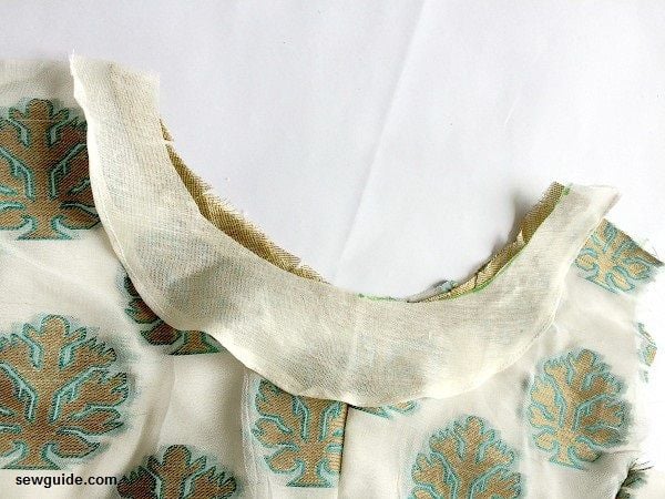 sewing piping cord on neckline -keep the facing on top and sew in place along the piping cord