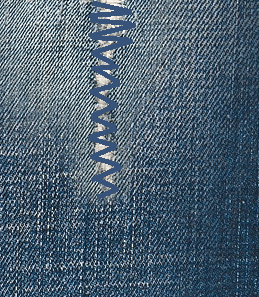 To sew a tear in a fabric with the zigzag stitching done over the hole.